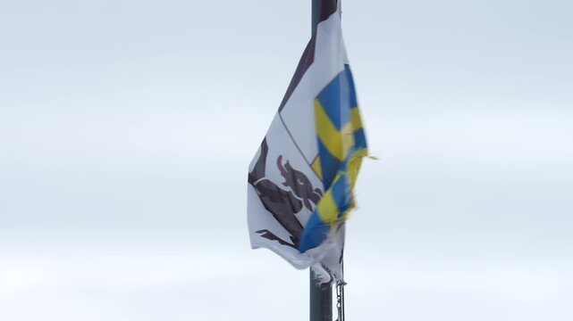 Tattered and torn grisons kanton flag waving