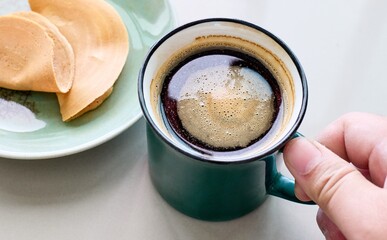 Hand pick a cup of coffee with crispy crepe