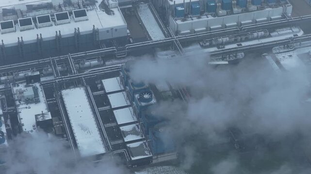 Aerial view of data center cooling system emitting steam during winter