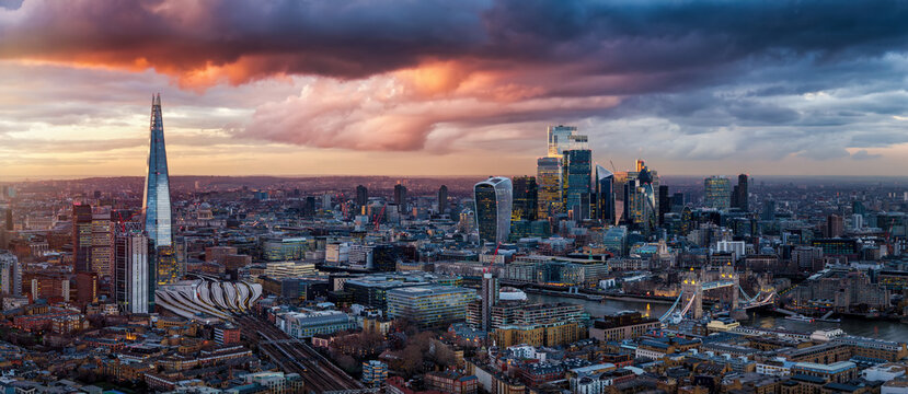 Panoramic sunset view of the cityscape of London, England, stretching from the City until Tower Bridge with dramatic cloudscape