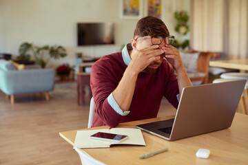 Stressed mid adult man working at home