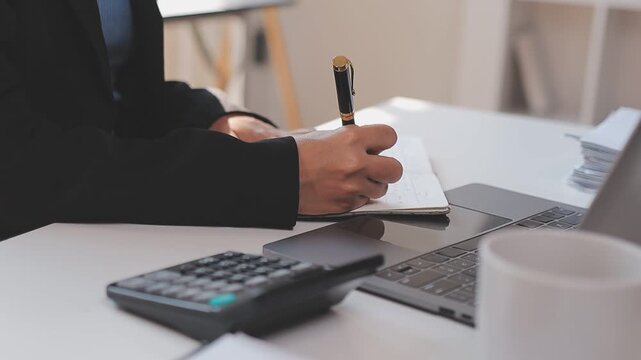 Elearning. Close up of smiling young female remote student watch training lecture on laptop pc take notes at paper workbook by hand. Millennial lady get distant education write thesis of online lesson