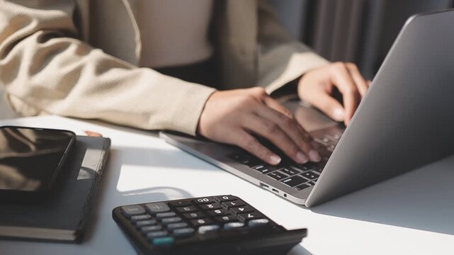 Closeup of the hands of a receptionist typing and sending emails while working in an office alone. One secretary doing admin and writing reports while organizing a schedule for her manager at work