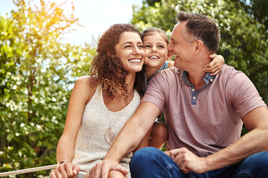 Happy, smile and parents with child in backyard for connection, bonding and fun on weekend. Family, outdoor and mom, dad and girl for holiday, vacation and playful relationship for love together