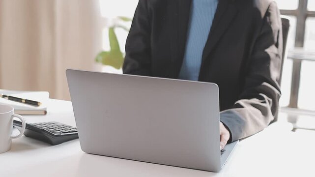 Closeup of the hands of a receptionist typing and sending emails while working in an office alone. One secretary doing admin and writing reports while organizing a schedule for her manager at work