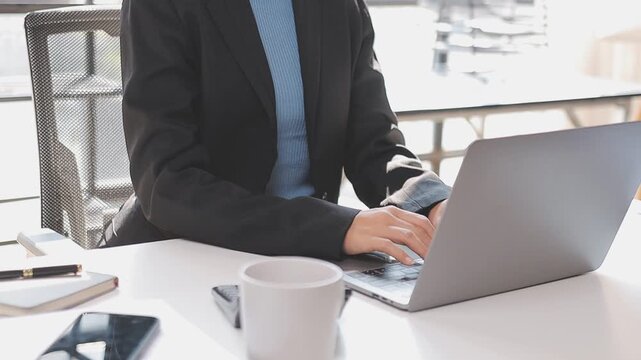 Closeup of the hands of a receptionist typing and sending emails while working in an office alone. One secretary doing admin and writing reports while organizing a schedule for her manager at work