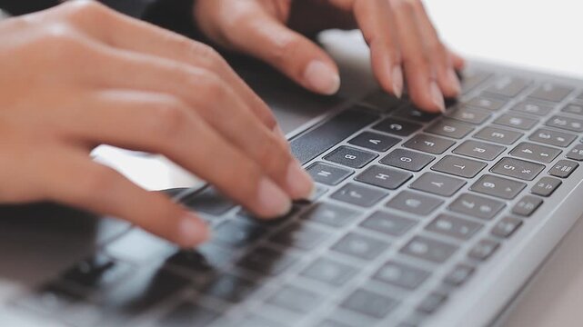 Closeup of the hands of a receptionist typing and sending emails while working in an office alone. One secretary doing admin and writing reports while organizing a schedule for her manager at work