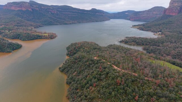 Sau pantano overflowing, january 2026 aerial view of the sau reservoir in catalonia, spain, showing the muddy floodwater of the ter river mixing with the clear reservoir water