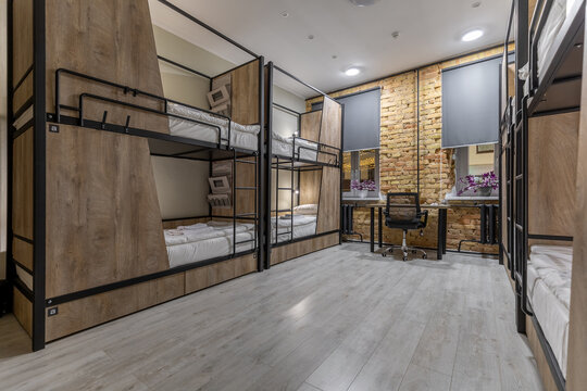 Modern loft hostel dormitory interior with bunk beds at night