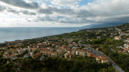 Obraz premium Aerial panorama of a coastal city, showing a dense array of residential and commercial buildings, with the sea on horizon. It is the waterfront of Paola, in the province of Cosenza, Calabria, Italy. 