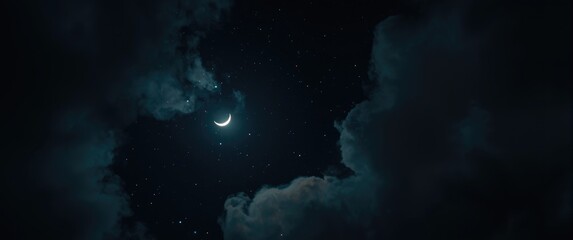 Naklejka premium Mysterious night sky featuring Crescent moon, glowing stars, and delicate clouds from a bottom-up perspective