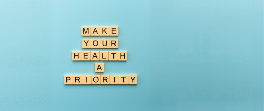 Wooden blocks spelling Make your health a Priority next to a Health symbol on a Beautiful blue background. Health concept. Copy space