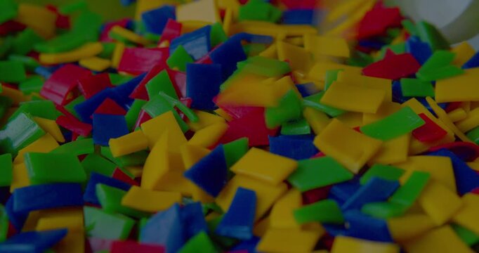 Footage of small vivid plastic pieces prepared for recycling purposes.