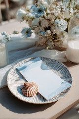 Beach wedding table setting with blank menu and coastal decor