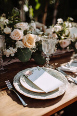 Rustic outdoor wedding table setting with flowers and invitation
