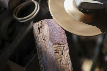 Close up of rustic wood and shiny brass metal in workshop. detail shows fine texture of handmade craftsmanship by an artisan, with calm, focused feeling