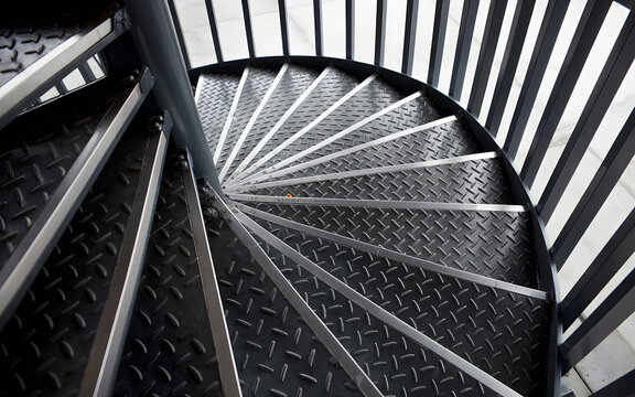 A spiral staircase with metal steps and railings viewed from above