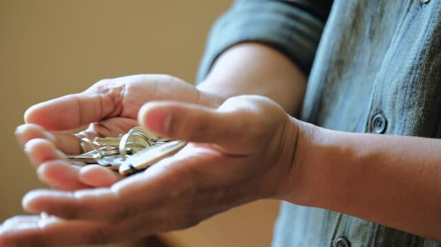 A close-up shot of a man&rsquo;s hand playing with a set of metal keys resting in his palm. The keys shift, slide, and lightly collide as the fingers move, creating clean, crisp metallic key sounds.
