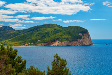 Naklejka premium beautiful seascape, view of sea and high cliff covered with forest in the distance