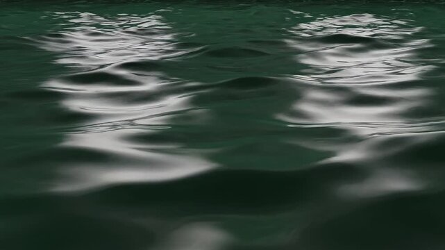 Dark green water ripples with soft light reflections create a moody liquid surface for organic skin care branding or atmospheric headers.