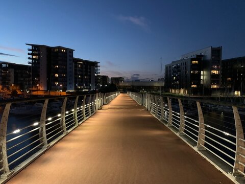 Illuminated pedestrian Pont y Werin bridge between Penarth and Cardiff at dusk, Wales, United Kingdom, July 2022