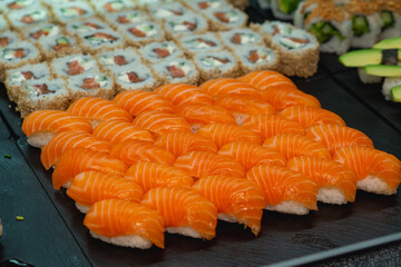 Delicious salmon sushi rolls and maki on black plate © Joose