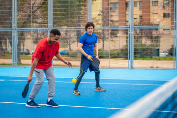 Obraz premium Young men playing pickleball game on court
