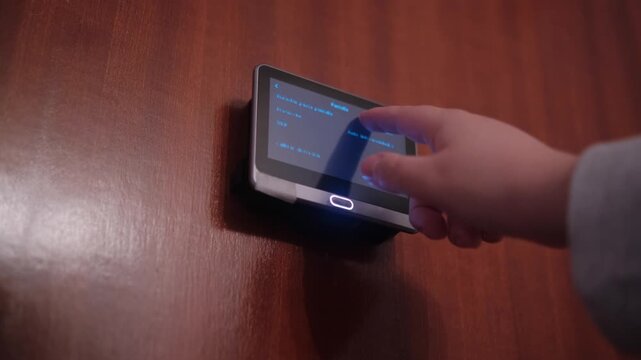 Woman hand setting up front door peephole security camera. Technology and home secure system concept. 