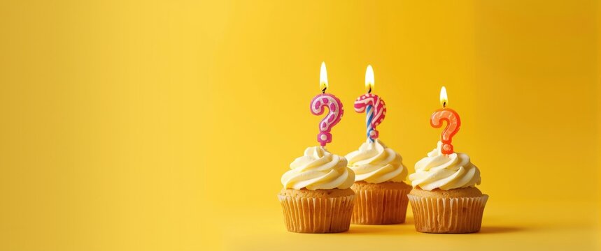 Birthday Cupcakes featuring lit Number 10 and Question Mark candles - Photo on Yellow background