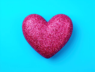 Obraz premium Glittering Pink Heart on Vibrant Cyan Background, Central Romance Symbol, Playful Valentine's Day Celebration, Whimsical Love Icon