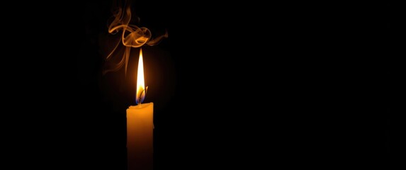 Dark backdrop illuminated by a close-up of a candle flame at night