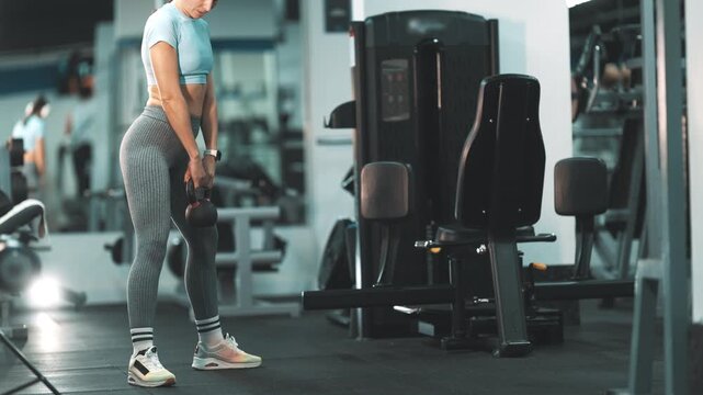 Fit woman performing kettlebell goblet squats