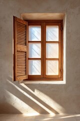 Obraz premium Sunlit wooden shuttered window casting shadows on textured wall in bright minimalist interior