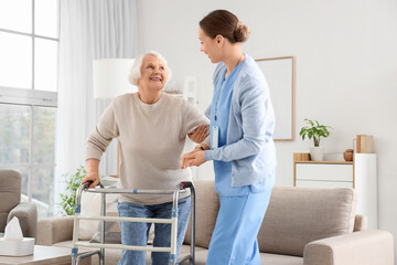 Obraz premium Nurse and senior woman with walker at home