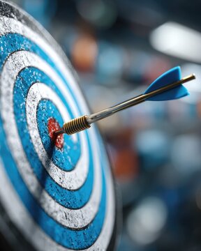 A blue and white target with an arrow directly in the bull's eye against a blurred background. The background symbolizes the achievement of goals and set results.