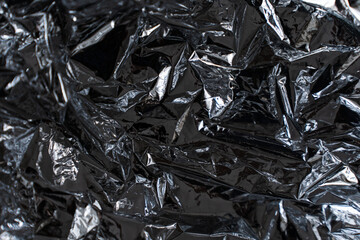 Dark crumpled metallic foil abstract texture