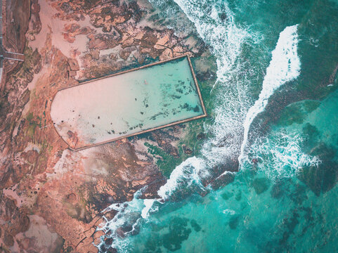 Aerial view of a man swimming in Cronulla Beach rock pool, New South Wales, Australia