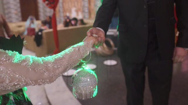 Couple holds hands while posing for a photo during a wedding celebration