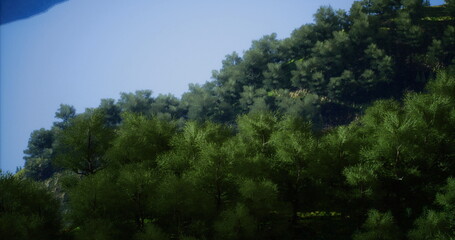 Obraz premium Lush green trees dominate the hillside, creating a peaceful atmosphere under the bright blue sky. The landscape conveys tranquility and natural beauty, ideal for outdoor activities.