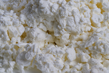 Closeup highprotein cottage cheese curds, dense moist texture with bright highlights, neutral background, ideal for nutrition marketing, meal prep shots, salad topping visuals