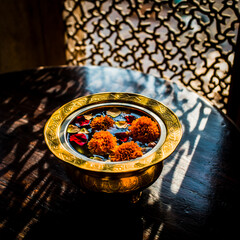 Cinematic Shot of Golden Indian Urli Featuring Floating Flowers and Soft Glow