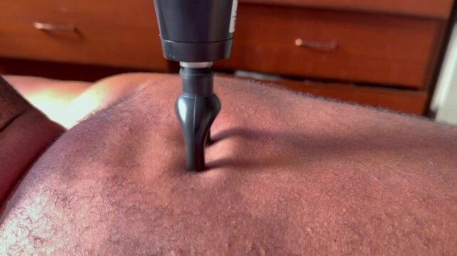 Slow motion of home back body massage with massage gun, with U-shaped head, Mahe, Seychelles 25fps 002