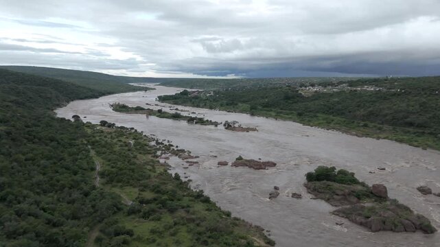 Smooth, cinematic drone footage slowly descending onto a flooding river in southern Kruger National Park, close to the Mozambique border.