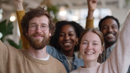 Obraz premium Group of four people, two men and two women, standing in a room with their arms raised in the air. they are all smiling and appear to be happy and excited.