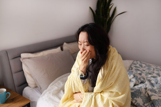 Illness, bed and woman blowing nose for sneeze, hayfever or allergies with recovery in home. Relax, sick and female person with tissue for sinusitis, cold or flu symptoms in bedroom at apartment.