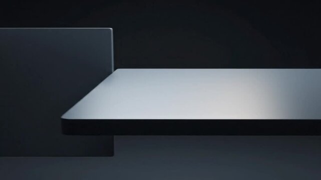 Simple, minimalist design of a modern shelving unit with a sleek, silver-toned surface against a dark background.