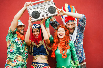 Happy dressed people celebrating at carnival party - Young friends having fun together at fest...