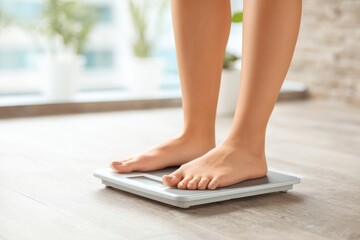 Woman Standing on Bathroom Scale with Natural Light from Window
