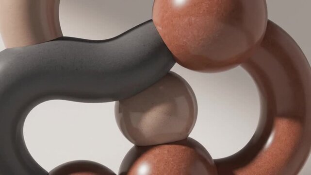 Close-up view of a sculpture composed of interconnected brown and gray metallic rings and spheres on a light gray background.