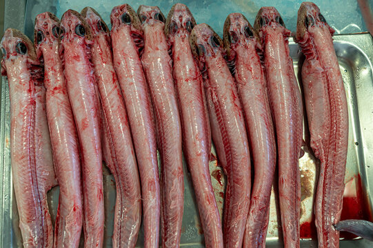 Freshly prepared fish displayed neatly on a metal tray in a market setting
